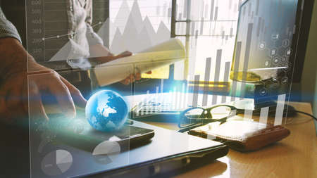 Businessman working at office desk and business graph interface on screen.の写真素材