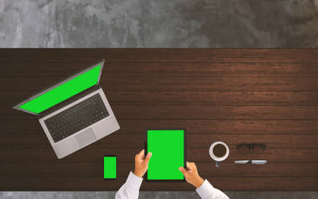 Businessman working at office desk with smart phone, tablet and laptop computer green screen.の写真素材