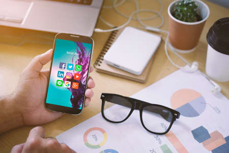 CHIANG MAI,THAILAND - February 12,2017: A man Holding Smartphone On Hand with application icons of social network on screenのeditorial素材