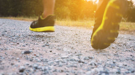 Athlete runner feet running on trail. Close-up of trail running shoeの写真素材