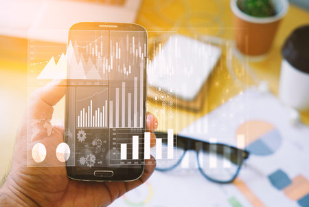 Businessman using smartphone and analysis diagram. Business graph background. financial graph       ...