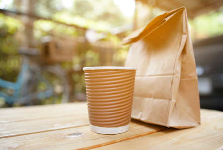 cup coffee and bread in paper bag.                        の写真素材