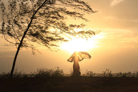 Young woman in the sunset on the beach.の写真素材