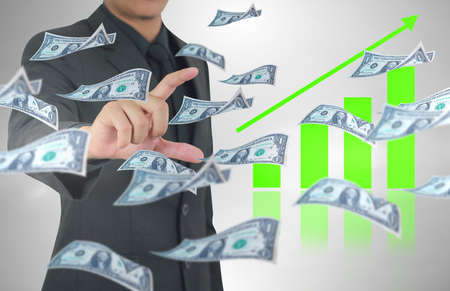 Businessman hloding dollar banknotes flying in the air. Finance and earning conceptの写真素材