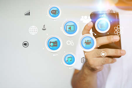 Hand touch screen smart phone, icons interface on screen, Social media, connect to the future concept.                               の写真素材