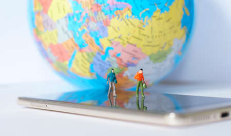Miniature traveler walking on world map. Travel concept.の写真素材