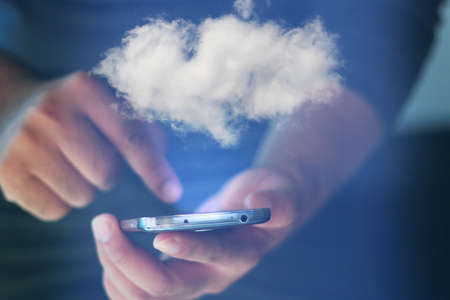 Businessman holding smartphone with cloud symbol. cloud computing conceptの写真素材