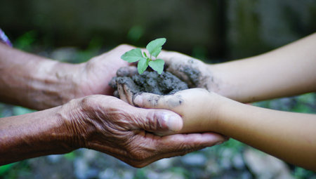 Little Girl and old man holding green plant. nature background