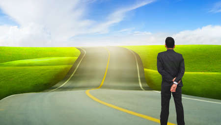 businessman standing and looking on the road. road to success concept.の写真素材
