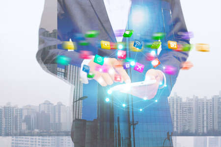 Businessman holding mobile smartphone with social icons.の写真素材