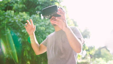 Young man wearing virtual reality glasses. Virtual reality concept, Smartphone and VR headset の写真素材
