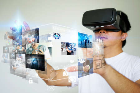 Young man wearing virtual reality glasses and touching on virtual screen. Virtual reality concept   の写真素材