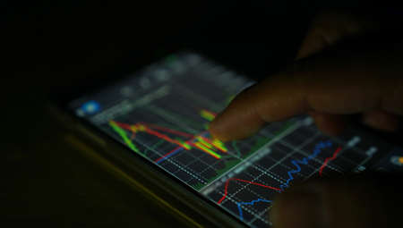 Businessman analyzing stock market chart on smartphone                                                         の写真素材