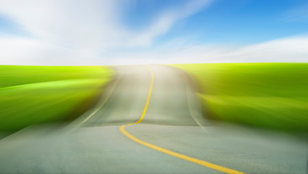 Road through the green field with motion blur.