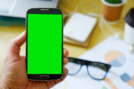 Businessman using mobile smartphone with green screen displayの写真素材