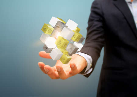 Businessman holding cube with business icons.の写真素材