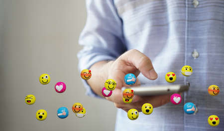 Man using smartphone sending text messages emoticon icons. Social network concept, 3d renderingの写真素材