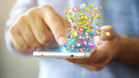 Man using smartphone sending text messages emoticon icons. Social network concept, 3d renderingの写真素材