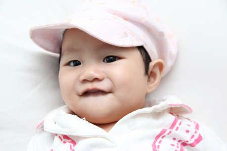 Asian baby about 6 months wearing beautiful capの写真素材