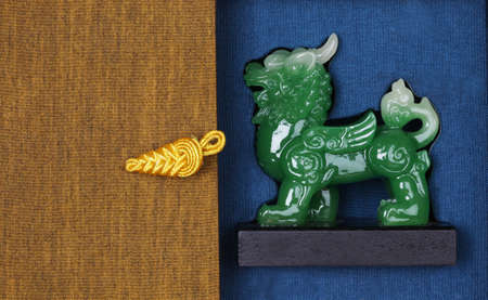 The lion statue the symbol of powerful in Chinese belief made from jade in box with beautiful rope handle  の写真素材