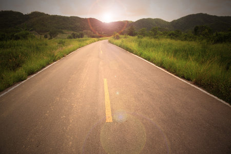 Country road to mountain with sun flare in concept go to target go to your destination