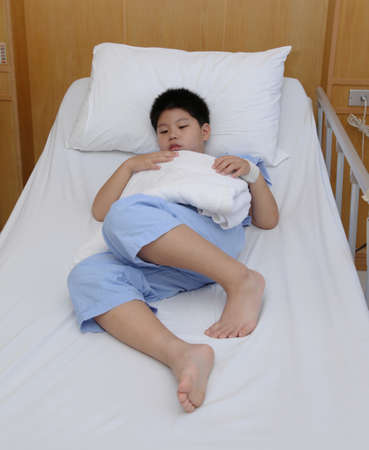 Young boy wear patient suit  in hospital bedの写真素材