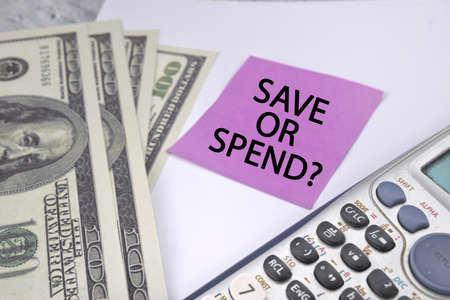 Save or spend wording with usd bank note and calculator with white background business and economy conceptの写真素材