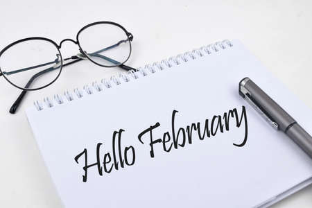 Selective focus image of pen and spectacles with Hello February wording. Business and life conceptの写真素材