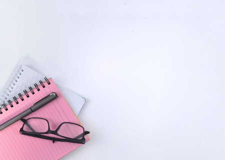 Selective focus image of spectacles and notebook on a white background with copy space. Conceptual...