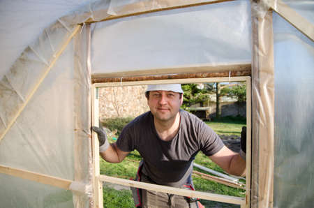 man builds a structure for a foliage in the garden, spring timeの写真素材