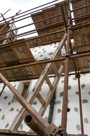 Thermal insulation of house wall with polystyrene. Picture of a scaffolding near familyhouse,...