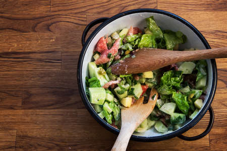 salad in retro bowl on wooden table top, top view, organic salad, homemadeの写真素材