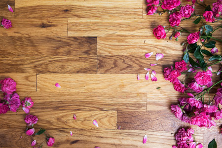 pink roses on brawn wooden background, view from above