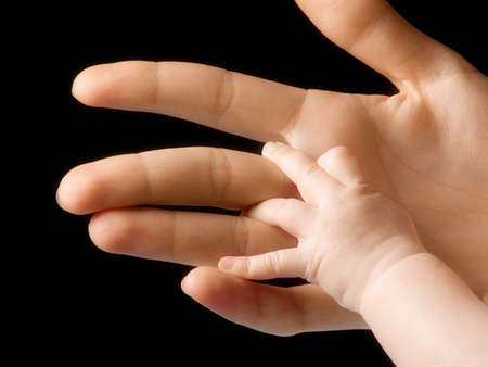 adult hand holding little handの写真素材