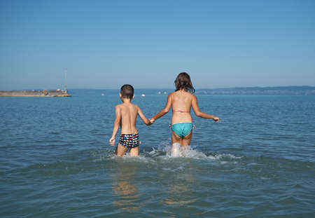 Little girl and littel boy playing in waterの写真素材