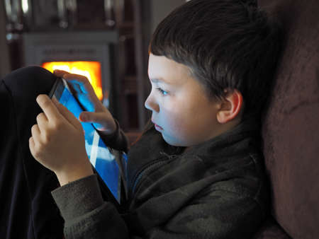 indoor shot young boy with mobileの写真素材