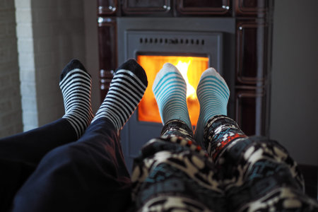 little girl and little boy warm up by the fireplace