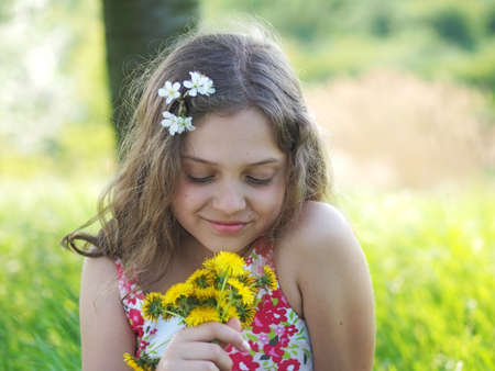 Outdoor little girl with bouquet of dandelionsの写真素材