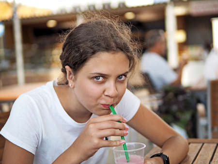 Young girl drinks lemonade in outdoor partyの写真素材