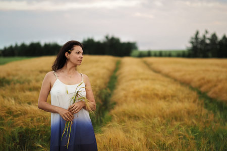 Portrait of young pretty woman without bra in barley field