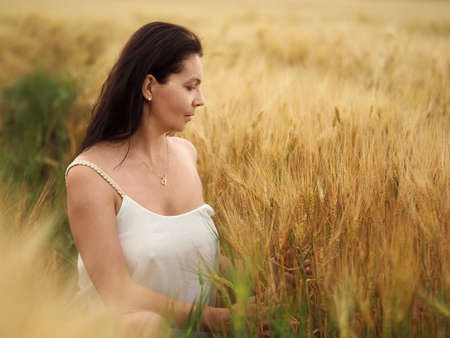 Portrait of young pretty woman without bra in barley fieldの写真素材