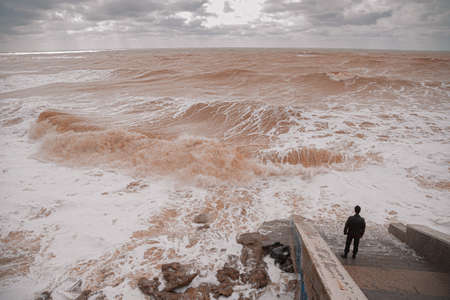 Man On The Steps Looks At The Storm In The Sea