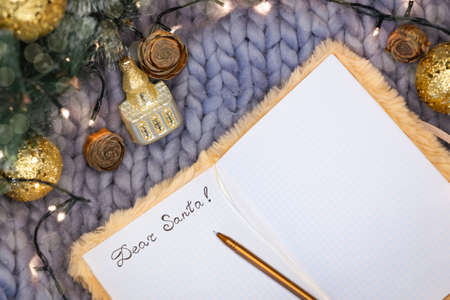 Notepad with the inscription dear santa on a gray knitted background with christmas decorations, flatlyの写真素材