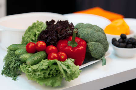 Composition of vegetables. On the plate is broccoli, cherry tomatoes, peppers, cucumbers