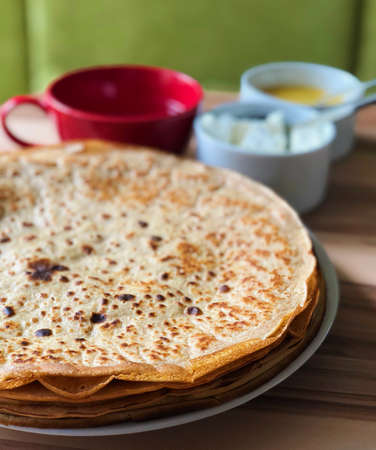 food Pancakes with local bee honey white cheese and tea and spoons on the background on focusの写真素材