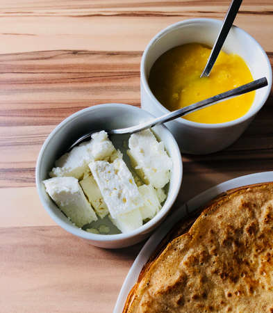 food Pancakes with local bee honey white cheese and spoons shot from aboveの写真素材