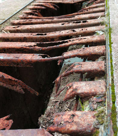Old and rusty decayed metal street shaft grid close up perspective