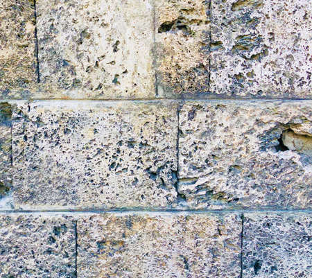 old decayed aged stone rock wall from an ancient building texture backgroundの写真素材