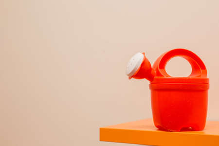 toy watering can on orange shelfの写真素材