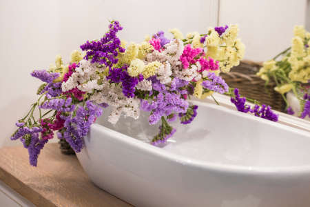 View of white washbasin with lavender flowersの写真素材
